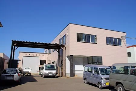 会社の建物正面と入口まわりが見える日中の外観